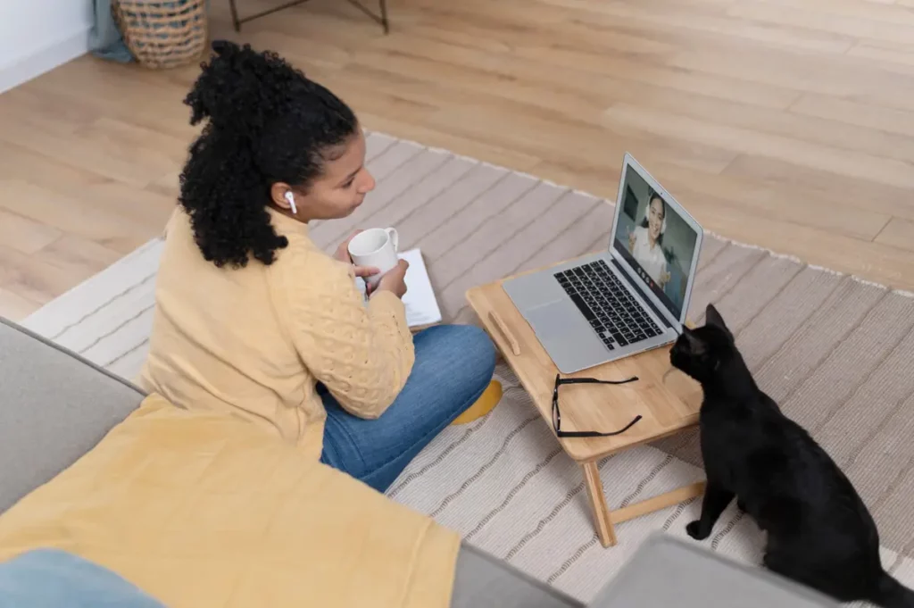 Sua tutora olhando video para gatos, e com cuidado com seu notebook para seu gato nao derrubar.